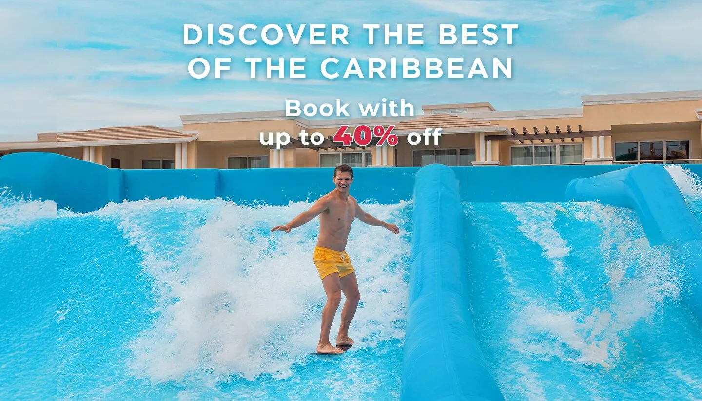 Guest surfing on a blue FlowRider-style wave attraction at Moon Palace Jamaica.