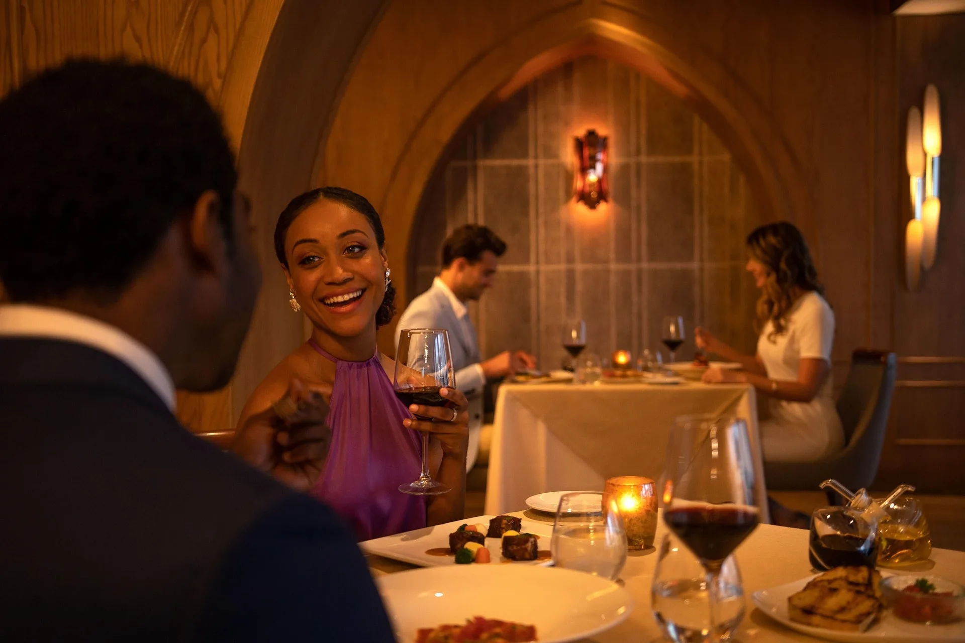 Couples dine by candlelight in a wood-paneled restaurant at Moon Palace Jamaica.