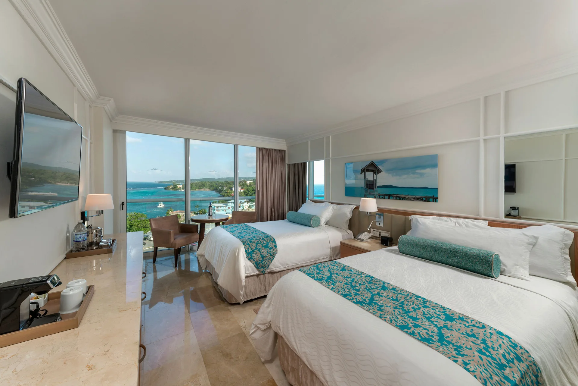 Deluxe Resort View room with two double beds and balcony windows at Moon Palace Jamaica.