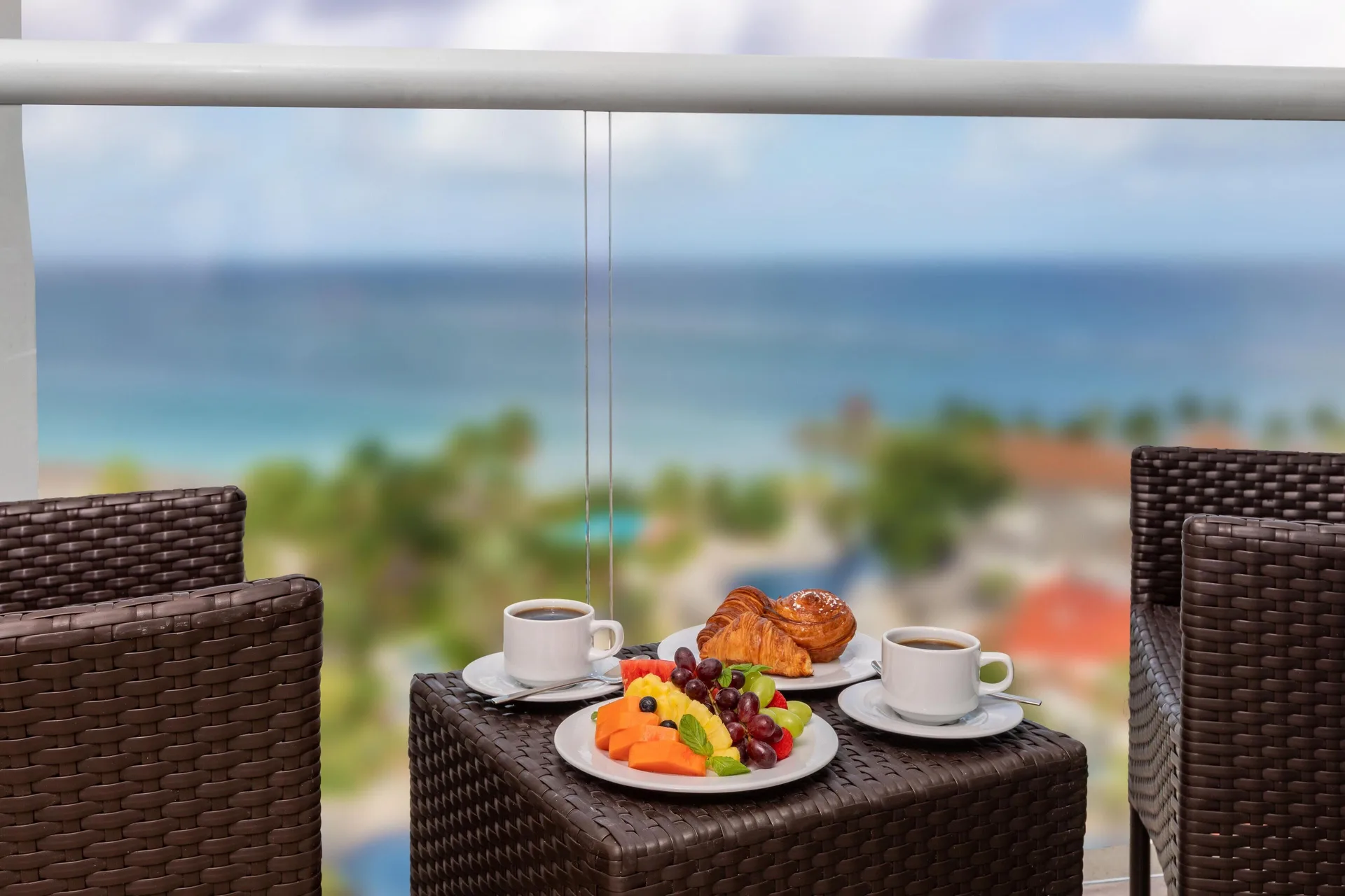 Balcony breakfast with wicker chairs and ocean beyond at Moon Palace Jamaica.