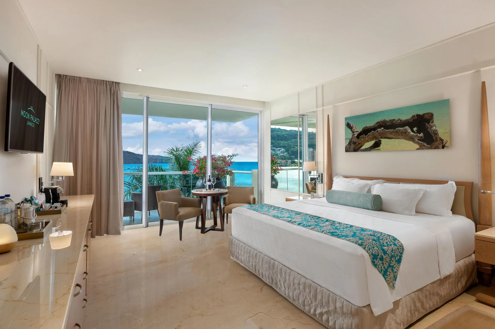 Superior Governor Suite ocean view king bed at Moon Palace Jamaica with turquoise water beyond the balcony.