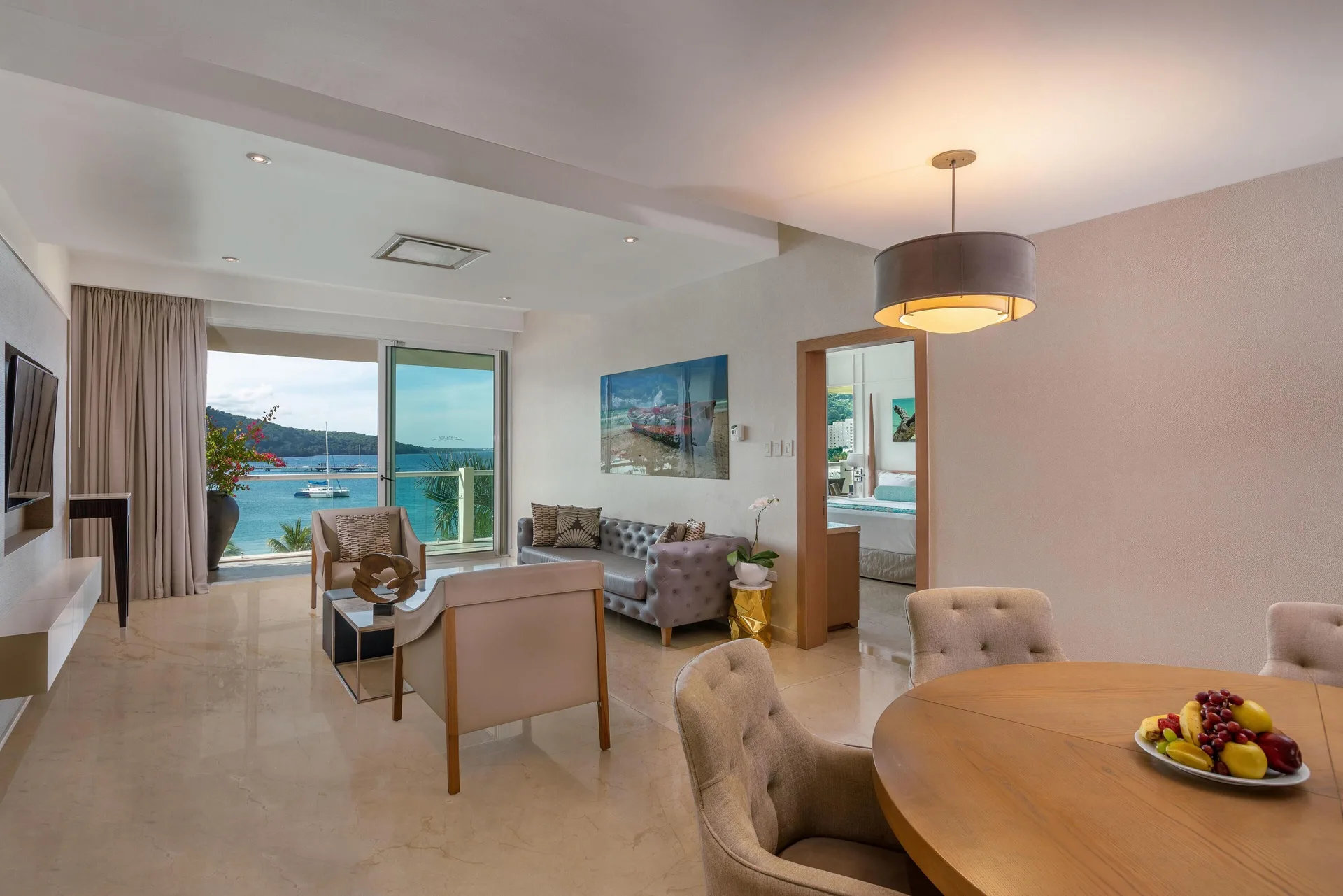 Superior Governor Suite ocean view living room at Moon Palace Jamaica with dining table and balcony.