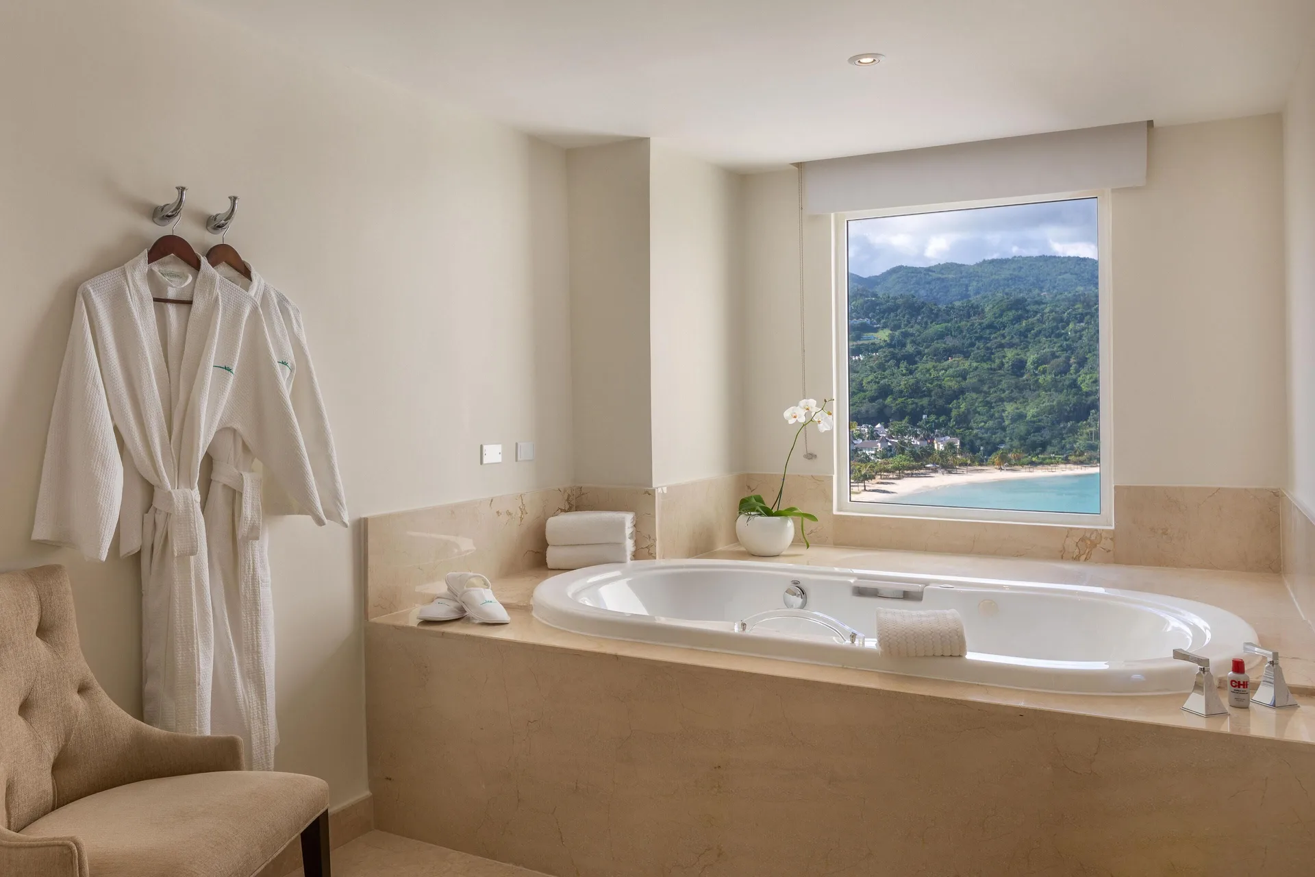 Soaking tub with ocean and hillside view in a presidential suite at Moon Palace Jamaica.