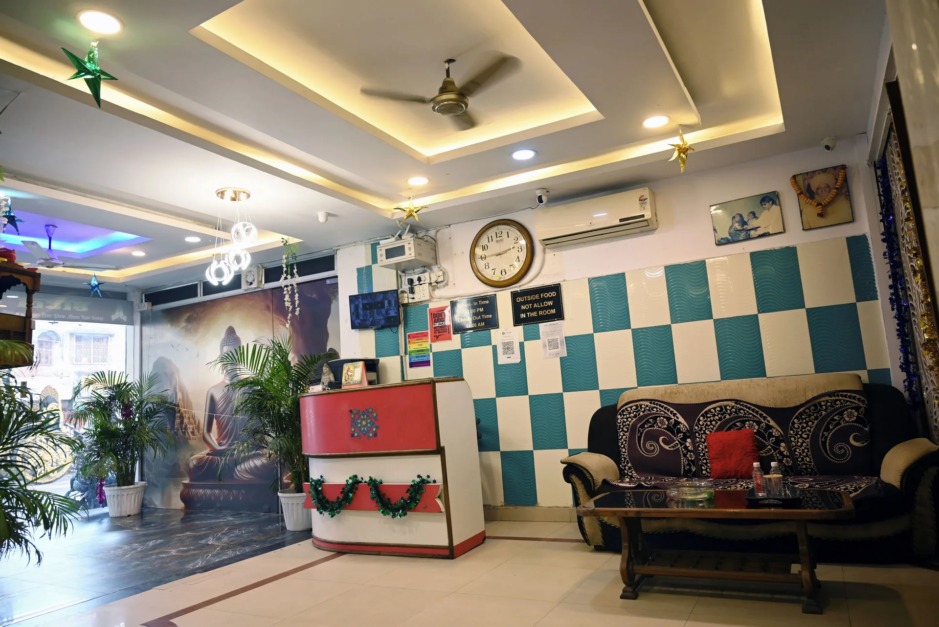 The Moon Palace lobby seating area with a reception desk, sofa, plants, and ceiling lights.
