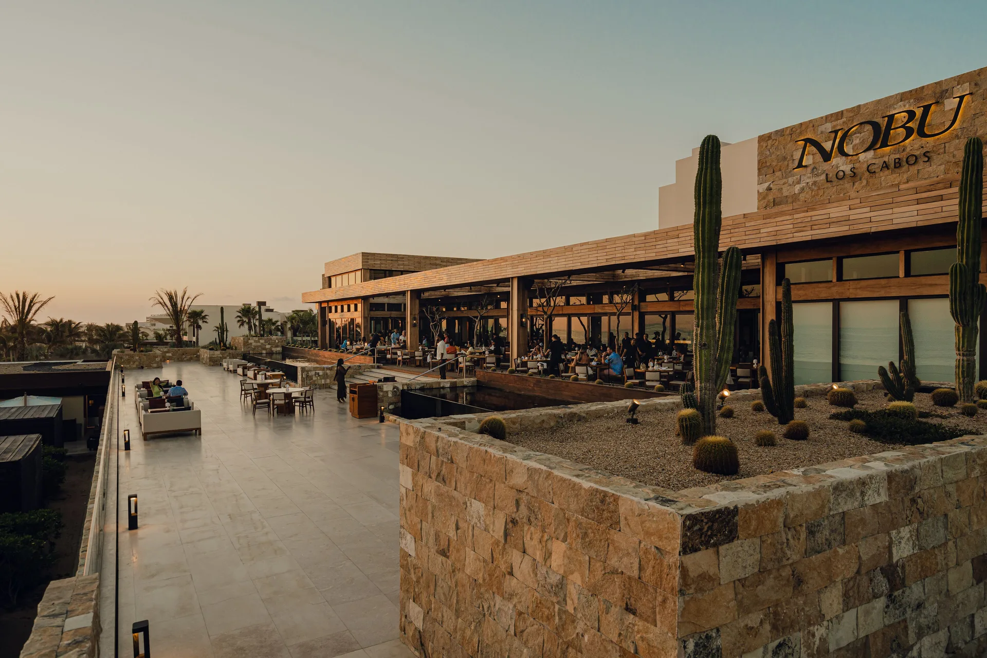 Nobu Hotel Los Cabos restaurant terrace and walkway at sunset at Nobu Hotel Los Cabos.