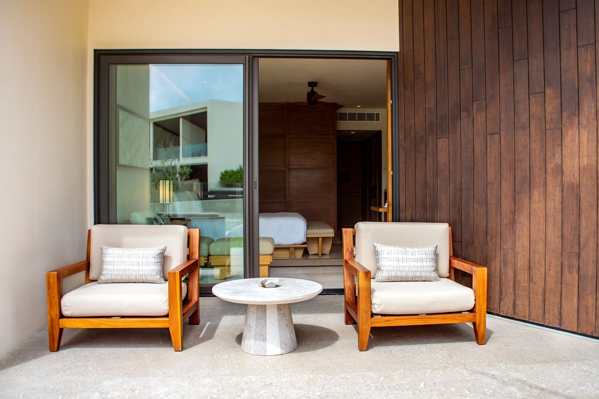 Deluxe Swim-Up Room patio with seating and sliding doors at Nobu Hotel Los Cabos.