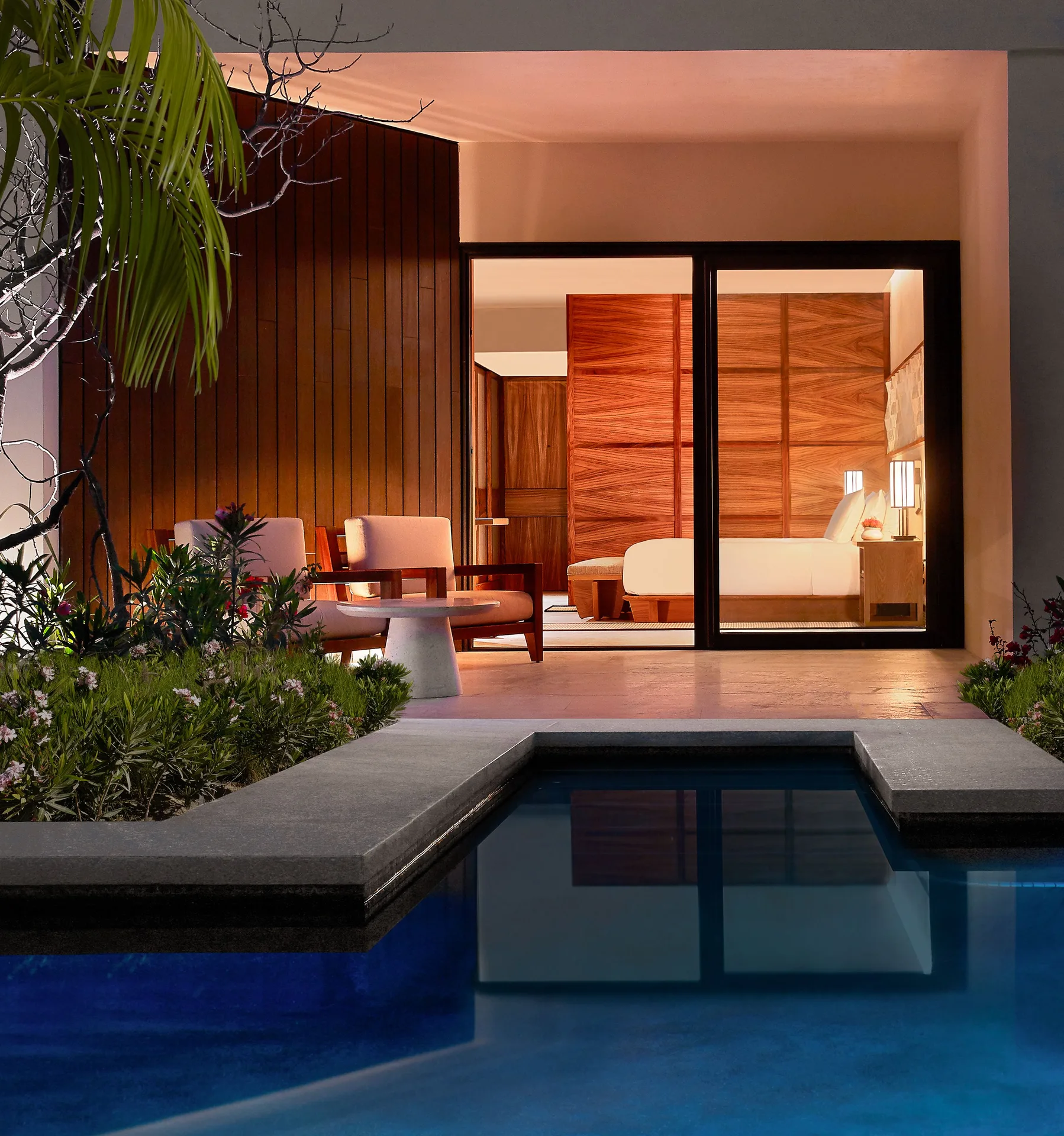 Deluxe Swim-Up Room patio and bedroom glowing at dusk at Nobu Hotel Los Cabos.