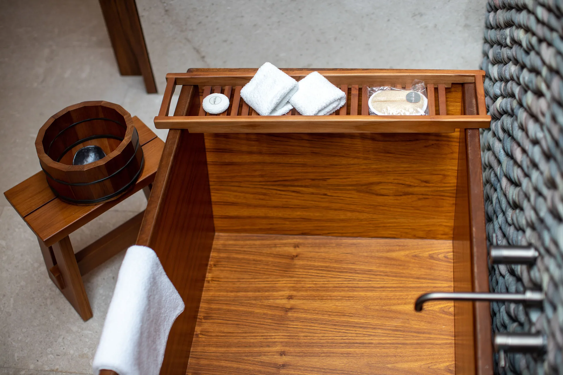 Deluxe Room soaking tub tray with towels and bath items at Nobu Hotel Los Cabos.