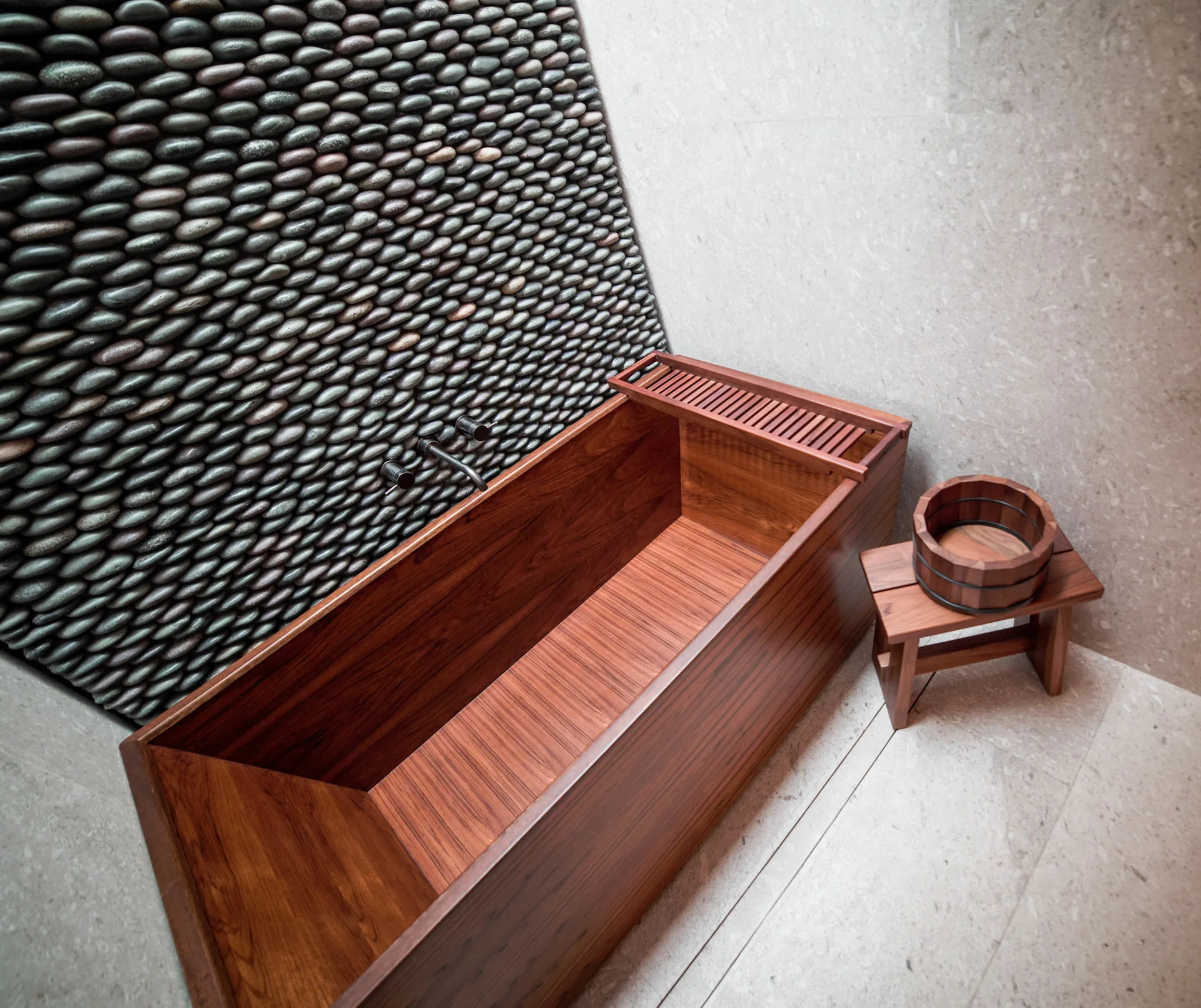 Deluxe Room wooden soaking tub with pebble wall at Nobu Hotel Los Cabos.