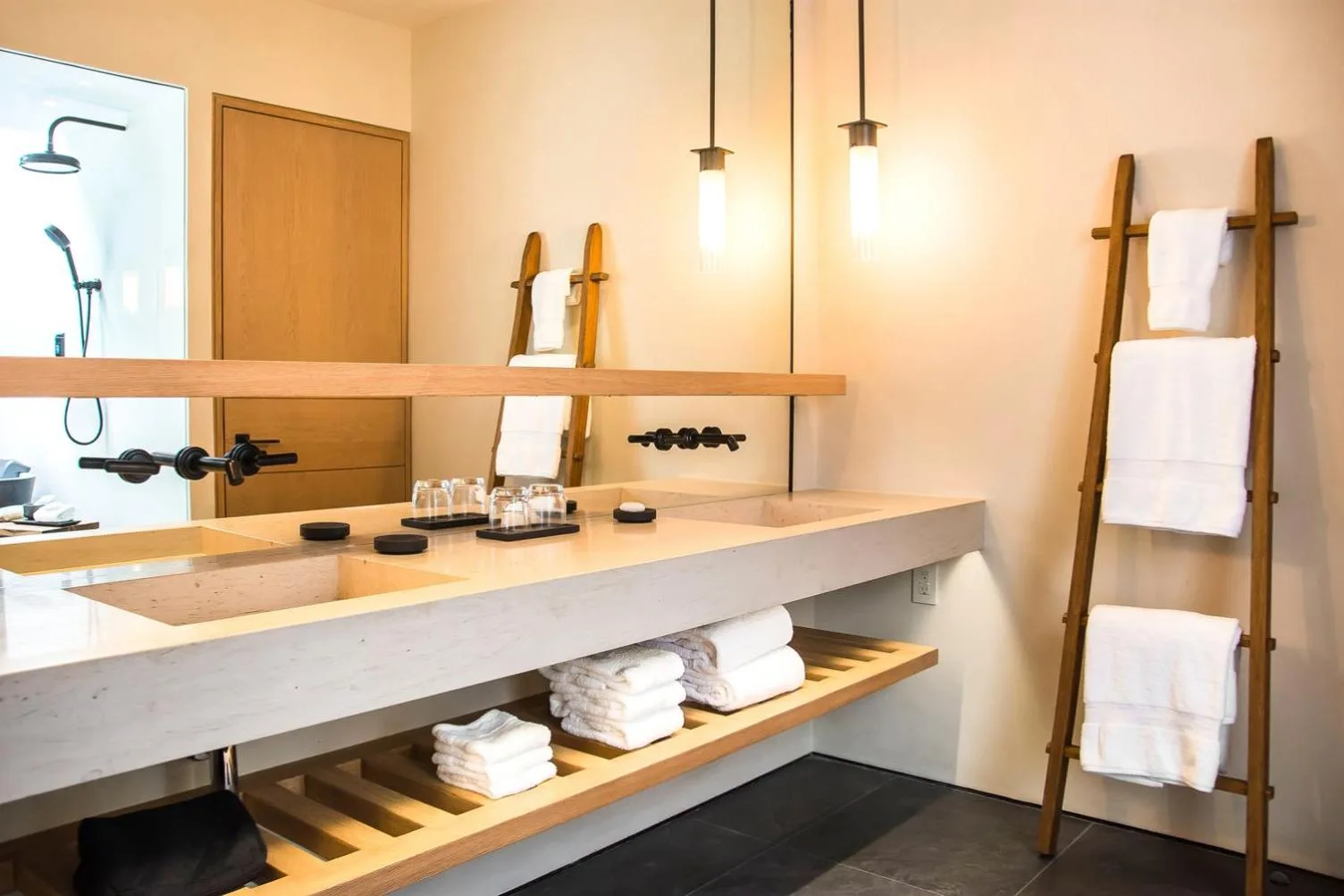 Deluxe bathroom vanity with double sinks, towels, and ladder rack at Nobu Hotel Los Cabos.