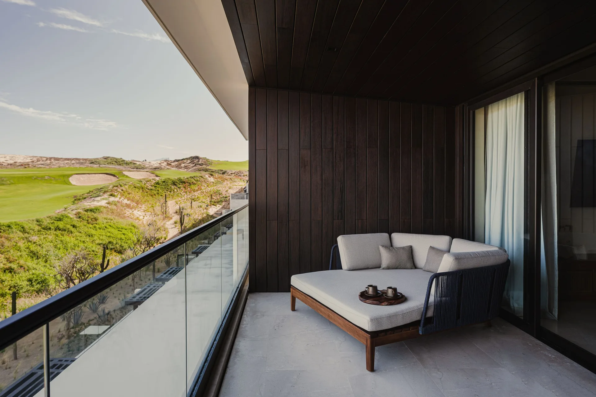 Hikari One Bedroom balcony daybed with golf course view at Nobu Hotel Los Cabos.