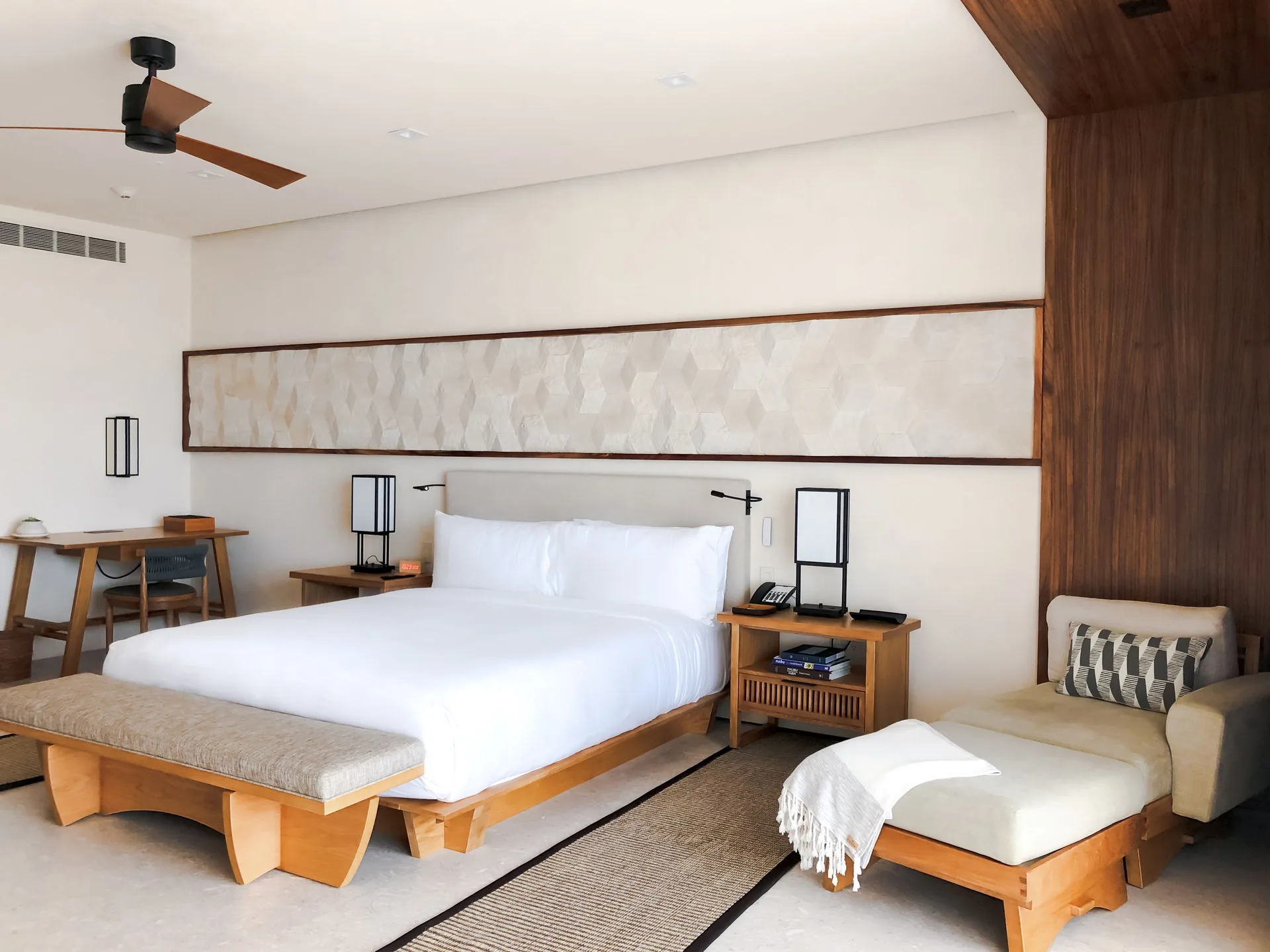 Junior Room king bed, desk, and chaise lounge at Nobu Hotel Los Cabos.