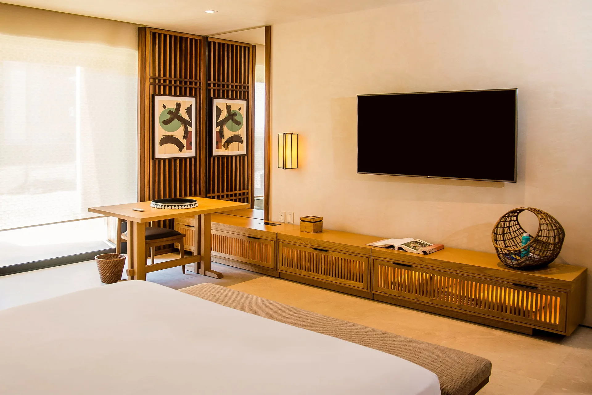 Junior Room with bed, desk, wall TV and wood accents at Nobu Hotel Los Cabos.