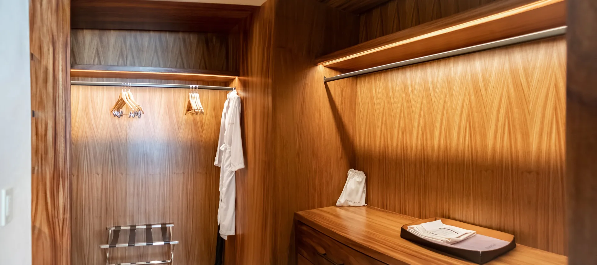 Junior Room walk-in closet with robes, hangers, and drawers at Nobu Hotel Los Cabos.
