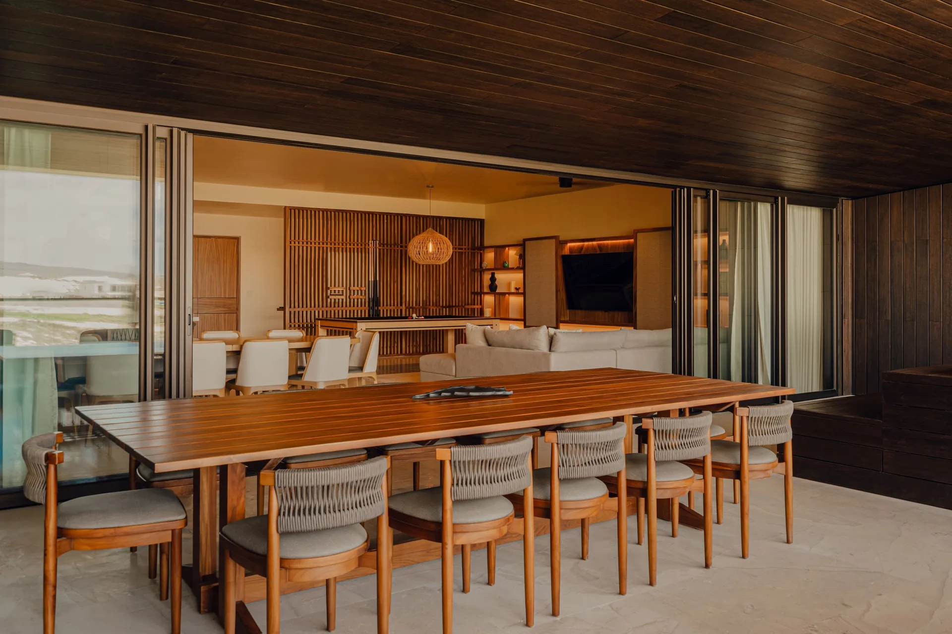 Outdoor dining table beside the living room in Kogane Penthouse at Nobu Hotel Los Cabos.