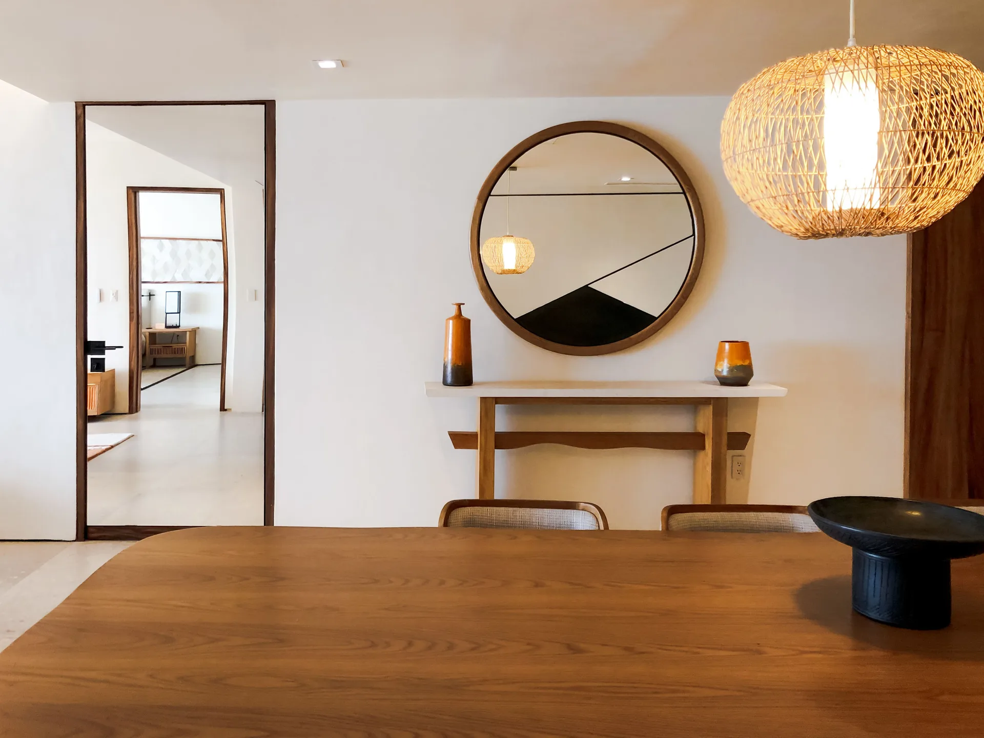 Ocean View Suite dining area with wood table and woven pendant at Nobu Hotel Los Cabos.