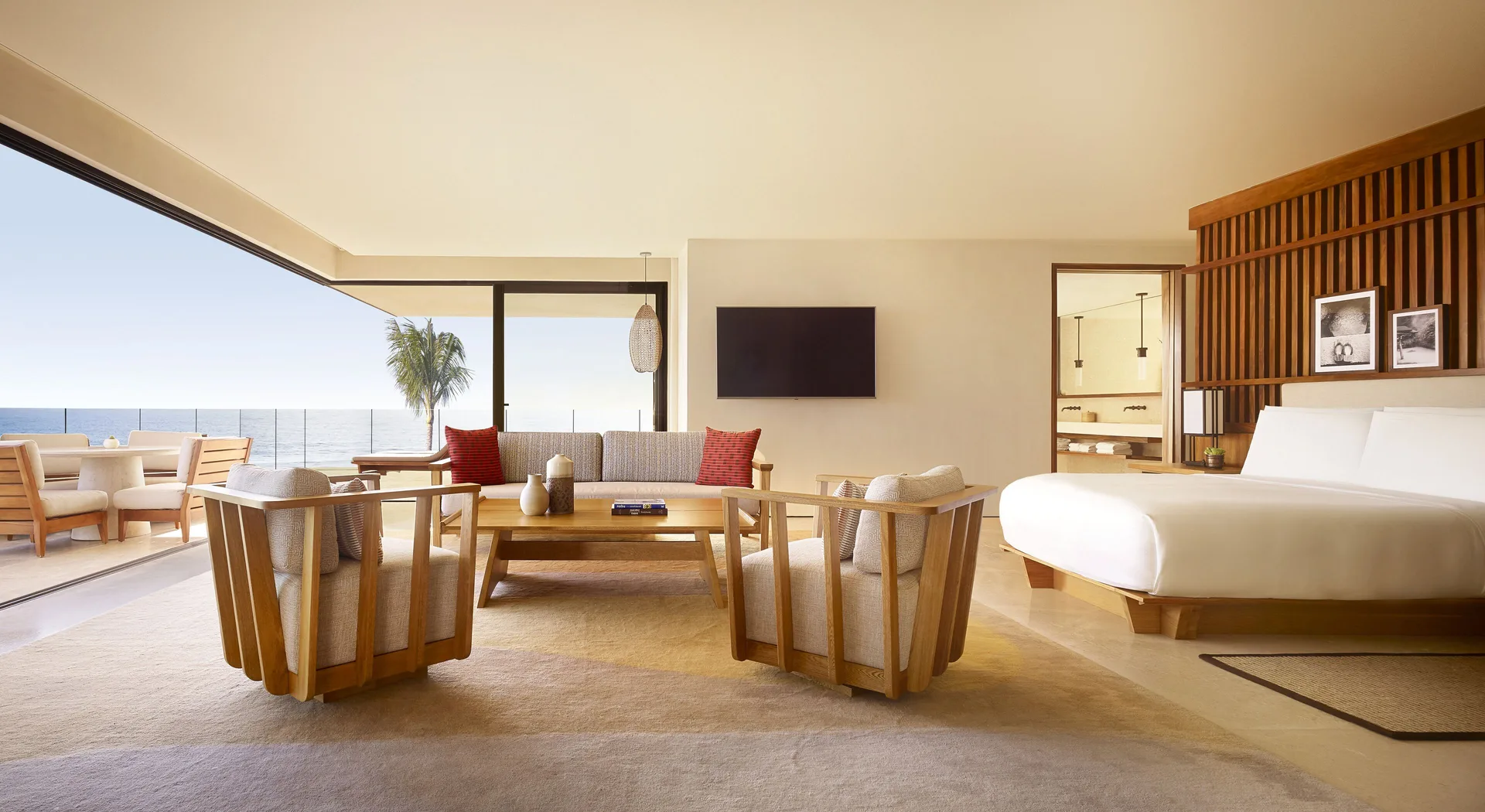 Suite Ocean View king bed, lounge seating, and open terrace at Nobu Hotel Los Cabos.