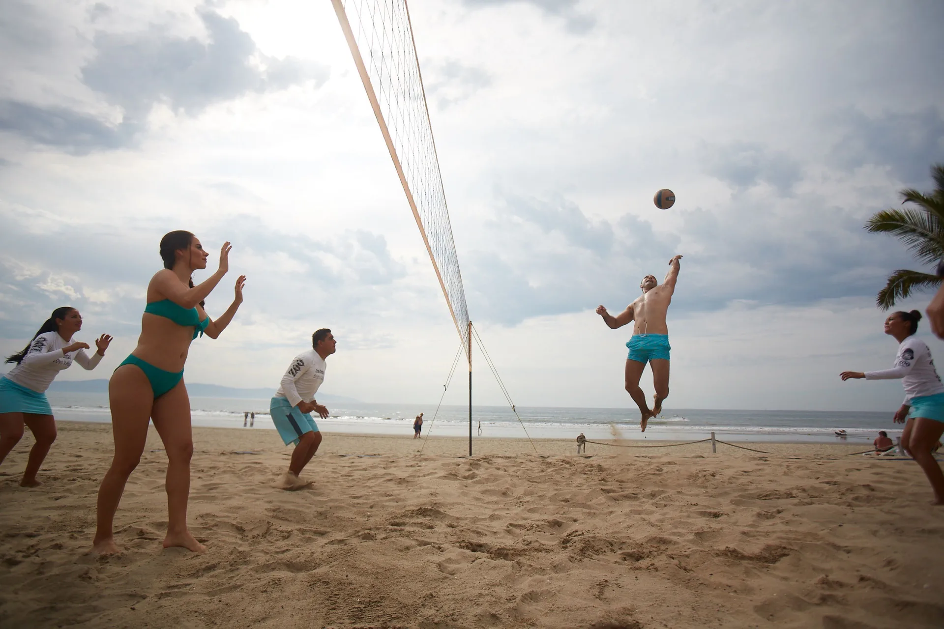Guests play beach volleyball by the ocean at Occidental Nuevo Vallarta.