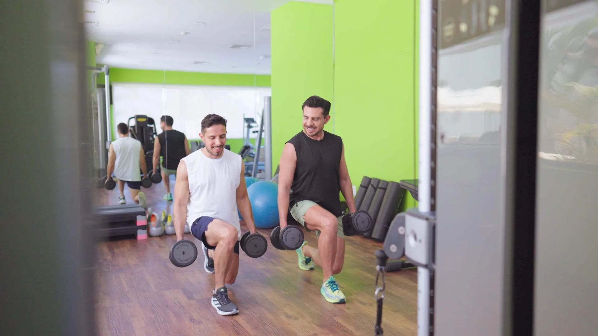 Two guests do dumbbell lunges in the fitness room at Occidental Nuevo Vallarta.