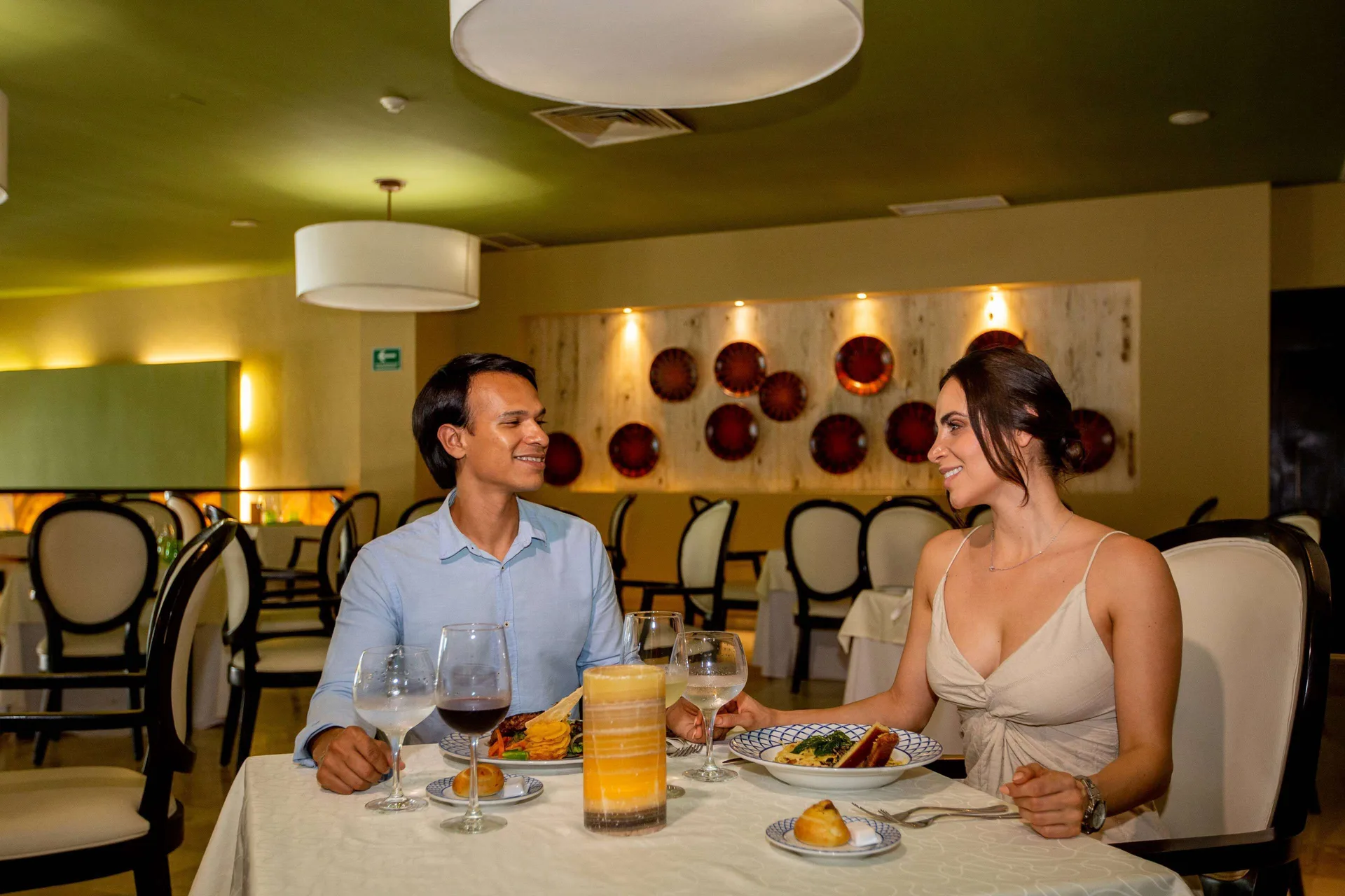 Couple dining at a white-clothed table inside Occidental Nuevo Vallarta.