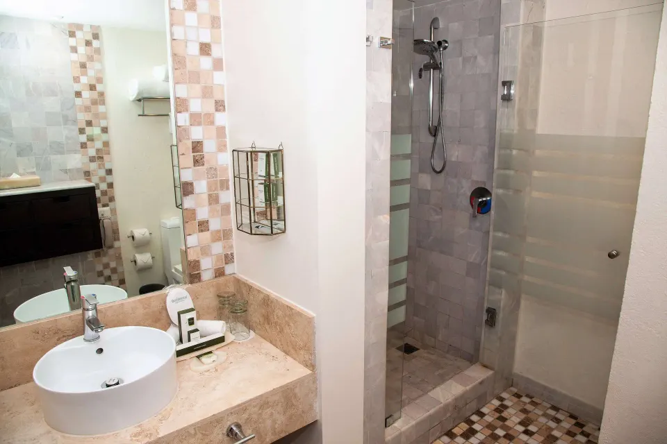 Deluxe Room bathroom with vanity and glass shower at Occidental Nuevo Vallarta.