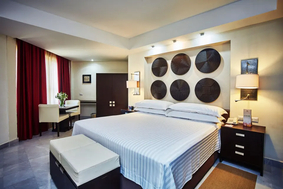 Deluxe Room king bed with seating area at Occidental Nuevo Vallarta.