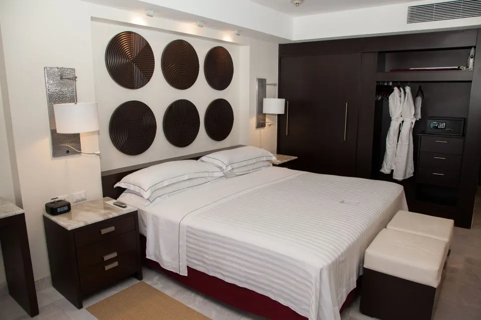Deluxe Room king bed with open wardrobe at Occidental Nuevo Vallarta.