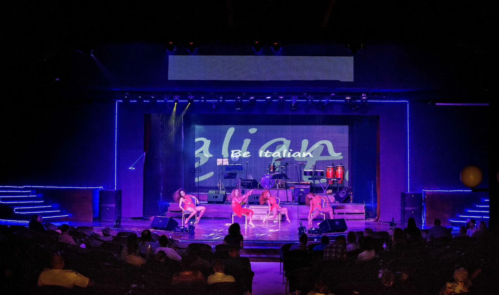 Stage show with dancers, instruments and blue lighting at Occidental Punta Cana.