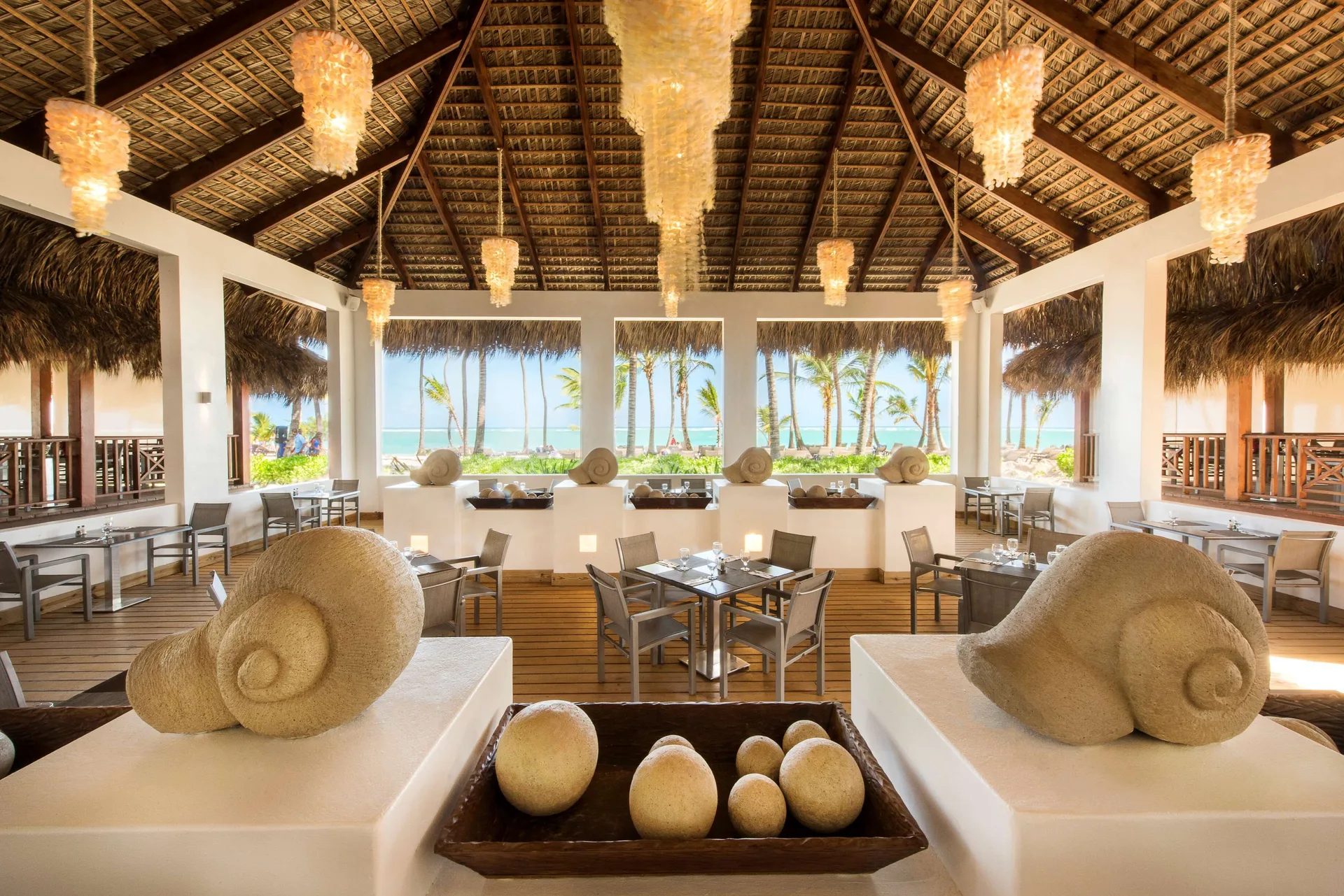 Beachfront open-air restaurant with thatched roof and shell decor at Occidental Punta Cana.