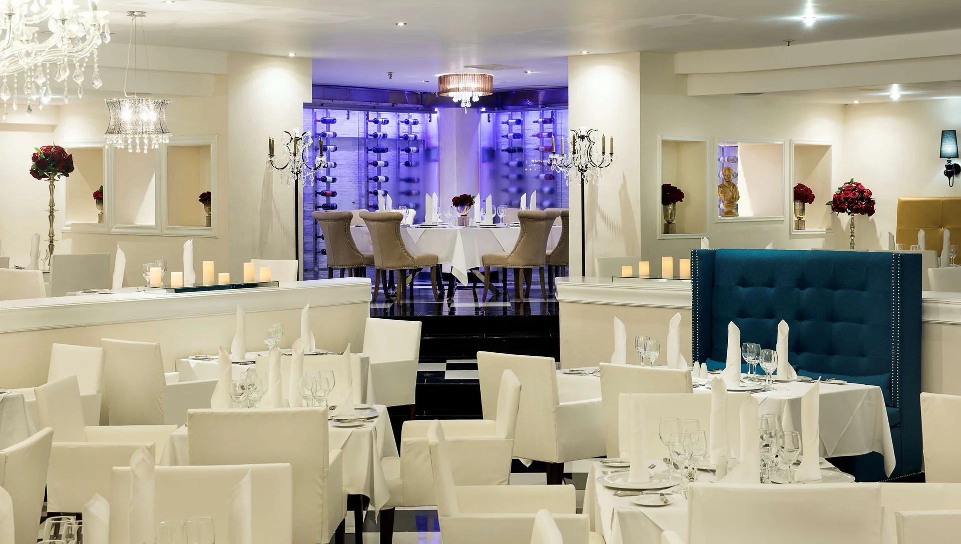 White restaurant tables facing a purple-lit private dining alcove at Occidental Punta Cana.