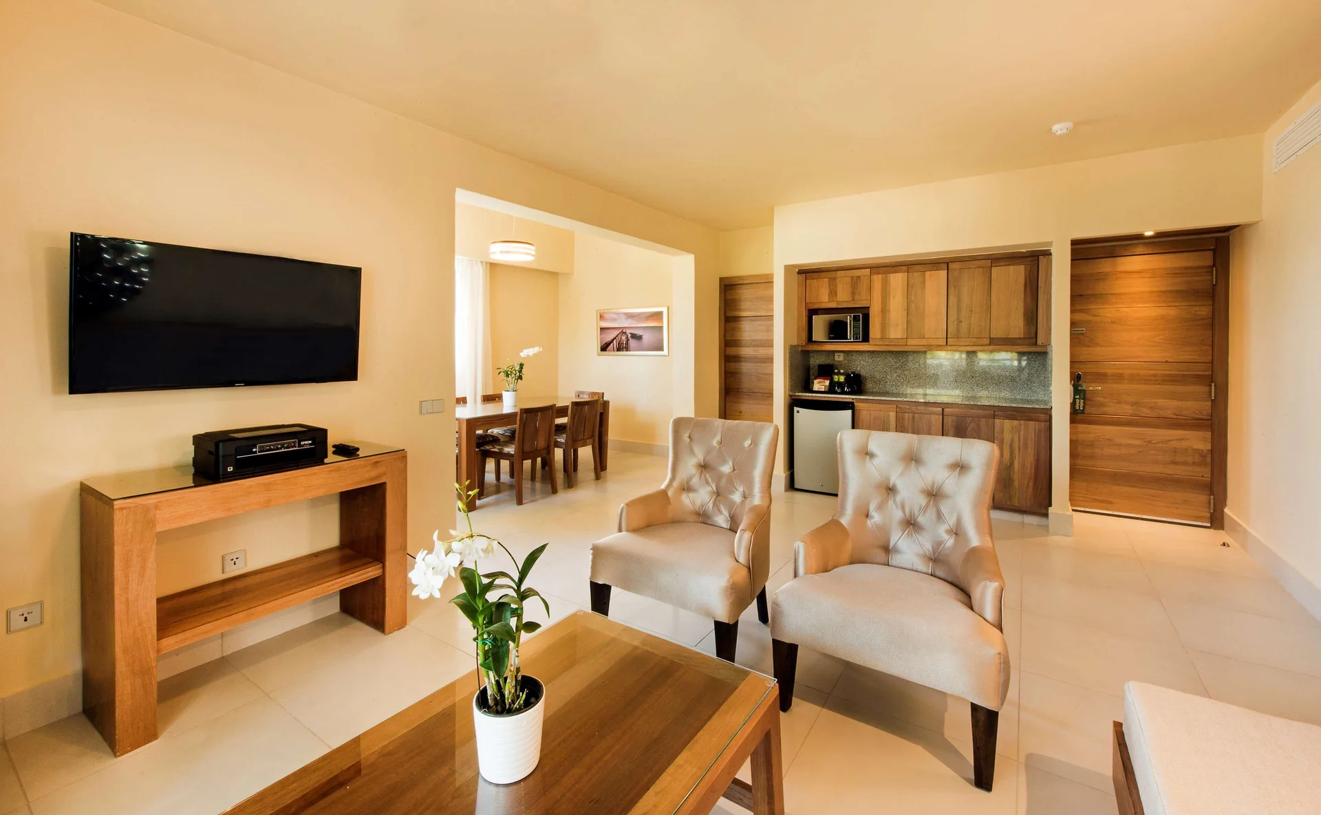 Royal Level Suite living area with chairs and kitchenette at Occidental Punta Cana.