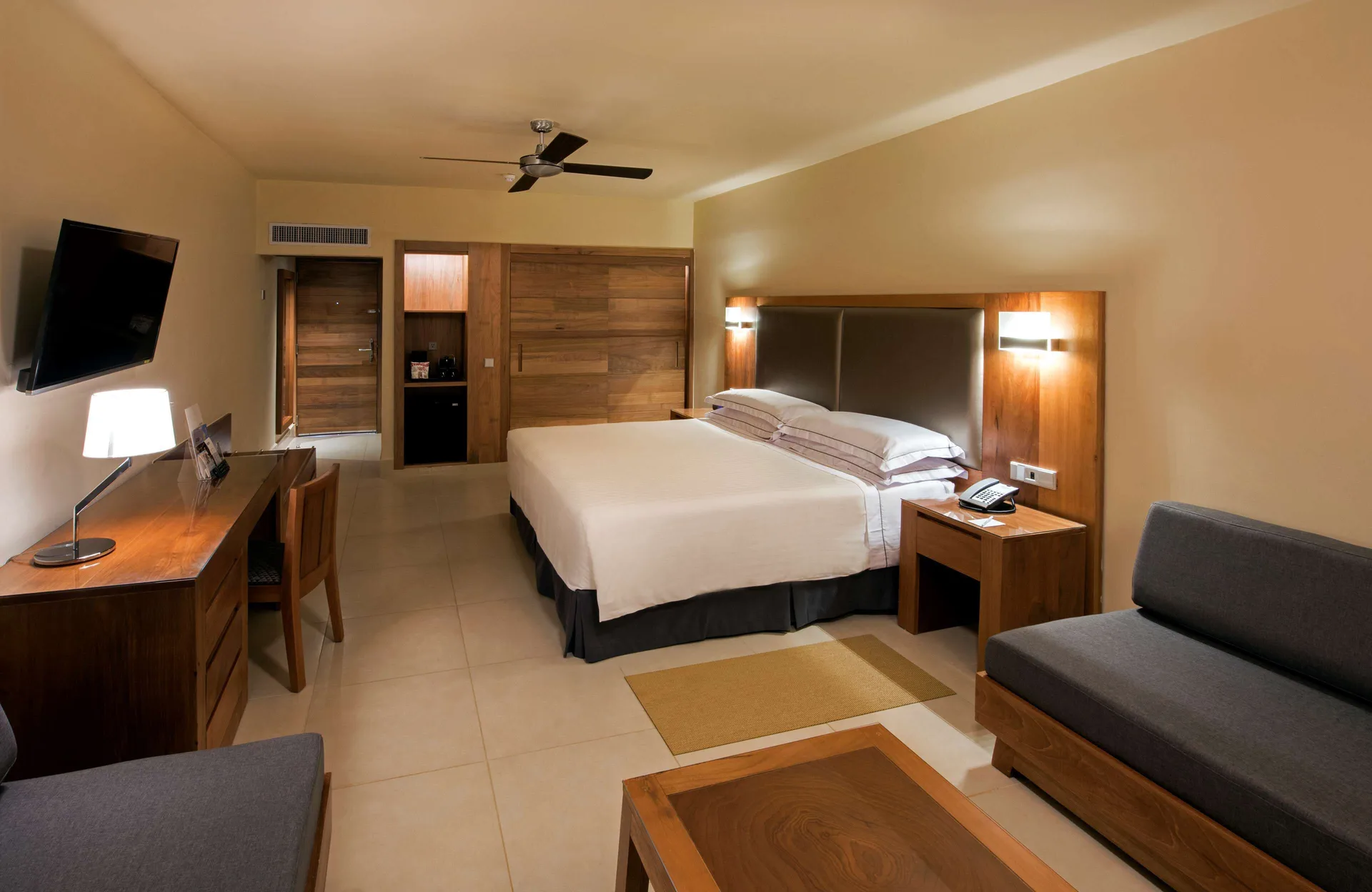 Superior Room Oceanfront with king bed, sofa, desk and wall TV at Occidental Punta Cana.