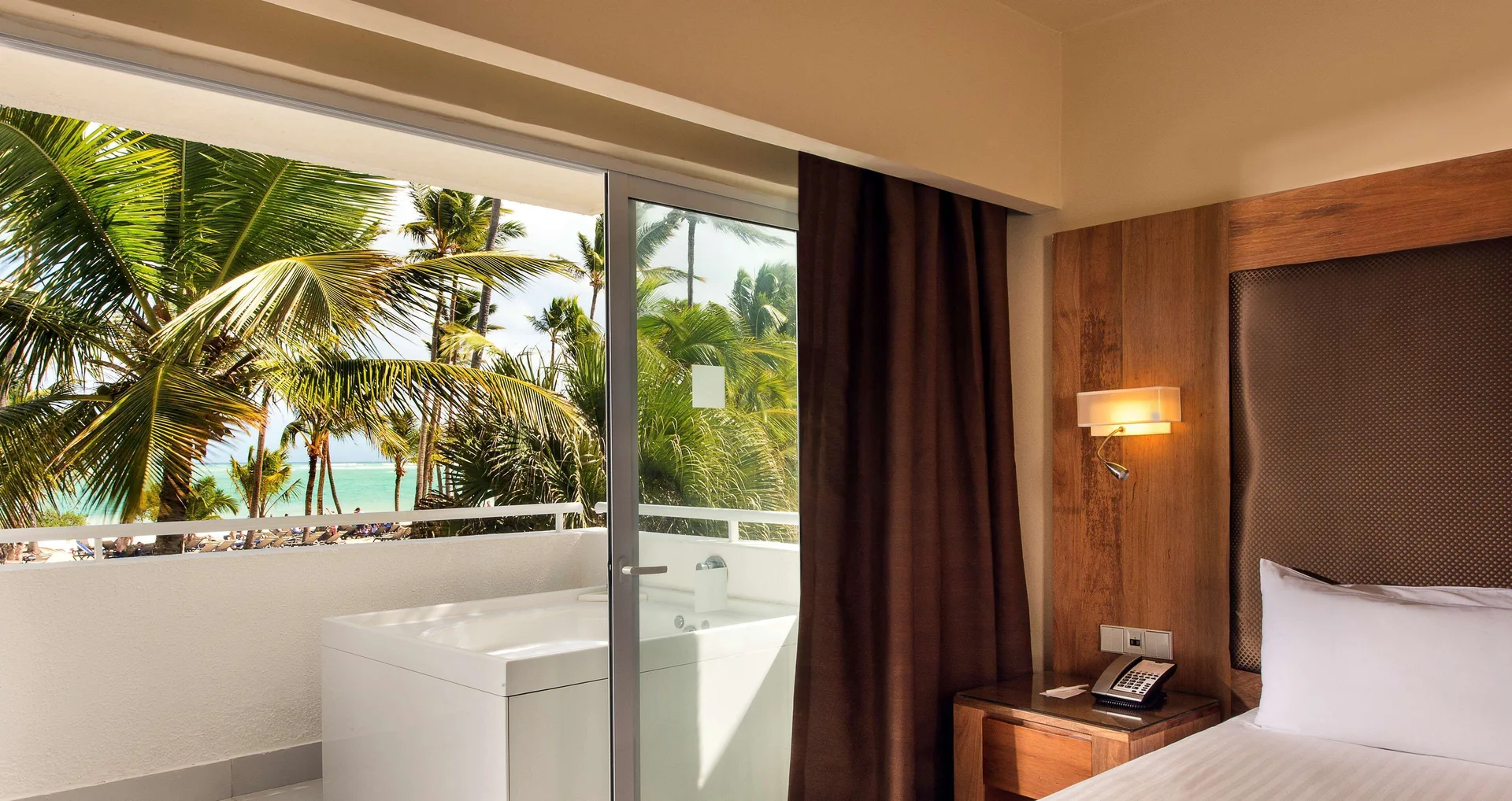Royal Level Superior Room bed and balcony with palms at Occidental Punta Cana.