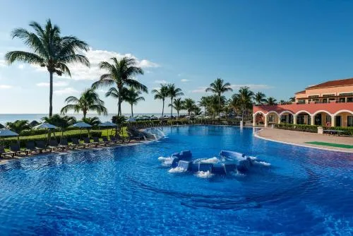Large oceanfront pool with palms and fountain at Ocean Coral and Turquesa.