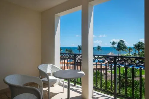 Junior Suite Elegance balcony view over palms and ocean at Ocean Coral and Turquesa.
