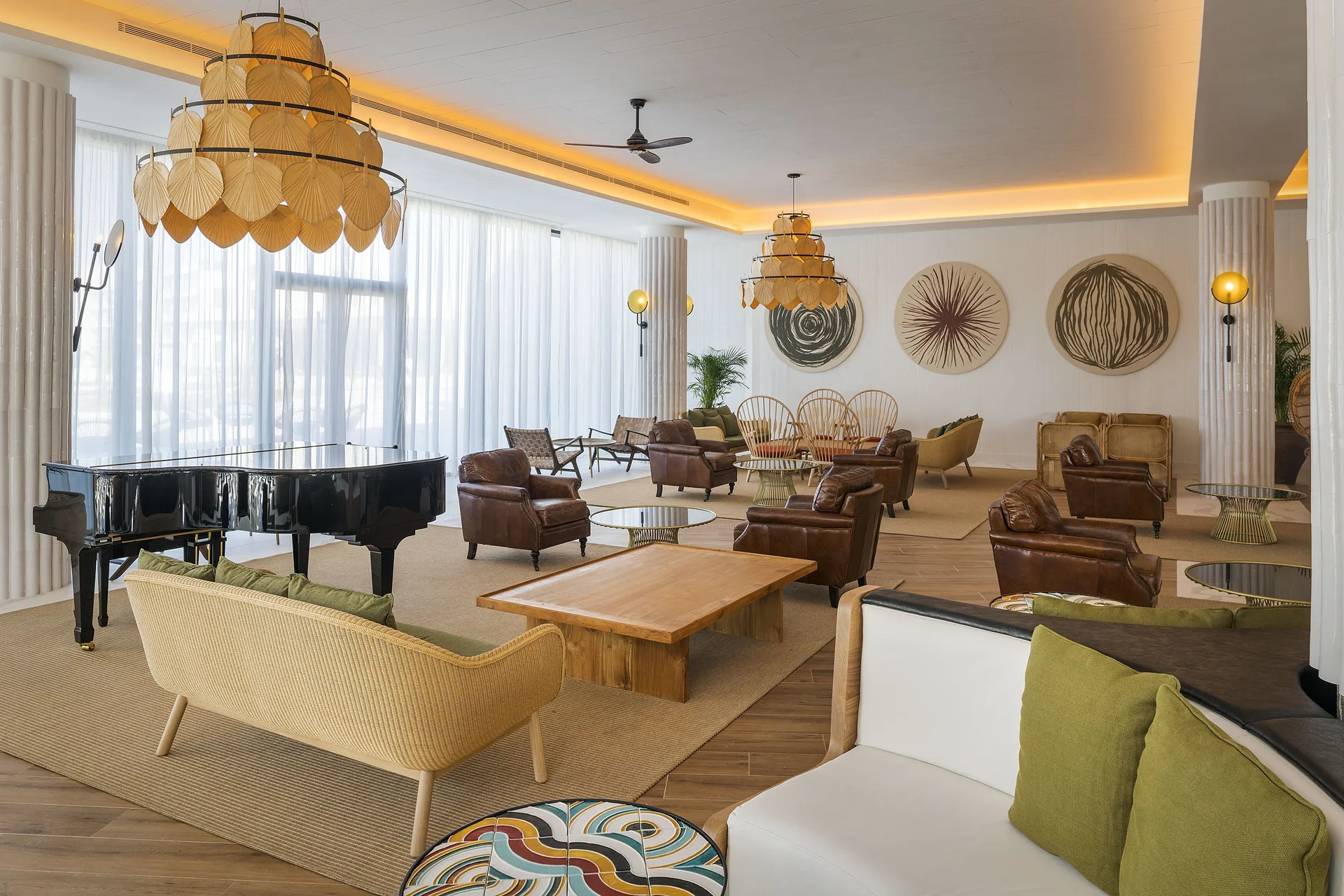 Lounge with grand piano, chandeliers, leather chairs, and woven sofas at Ocean Coral Spring.