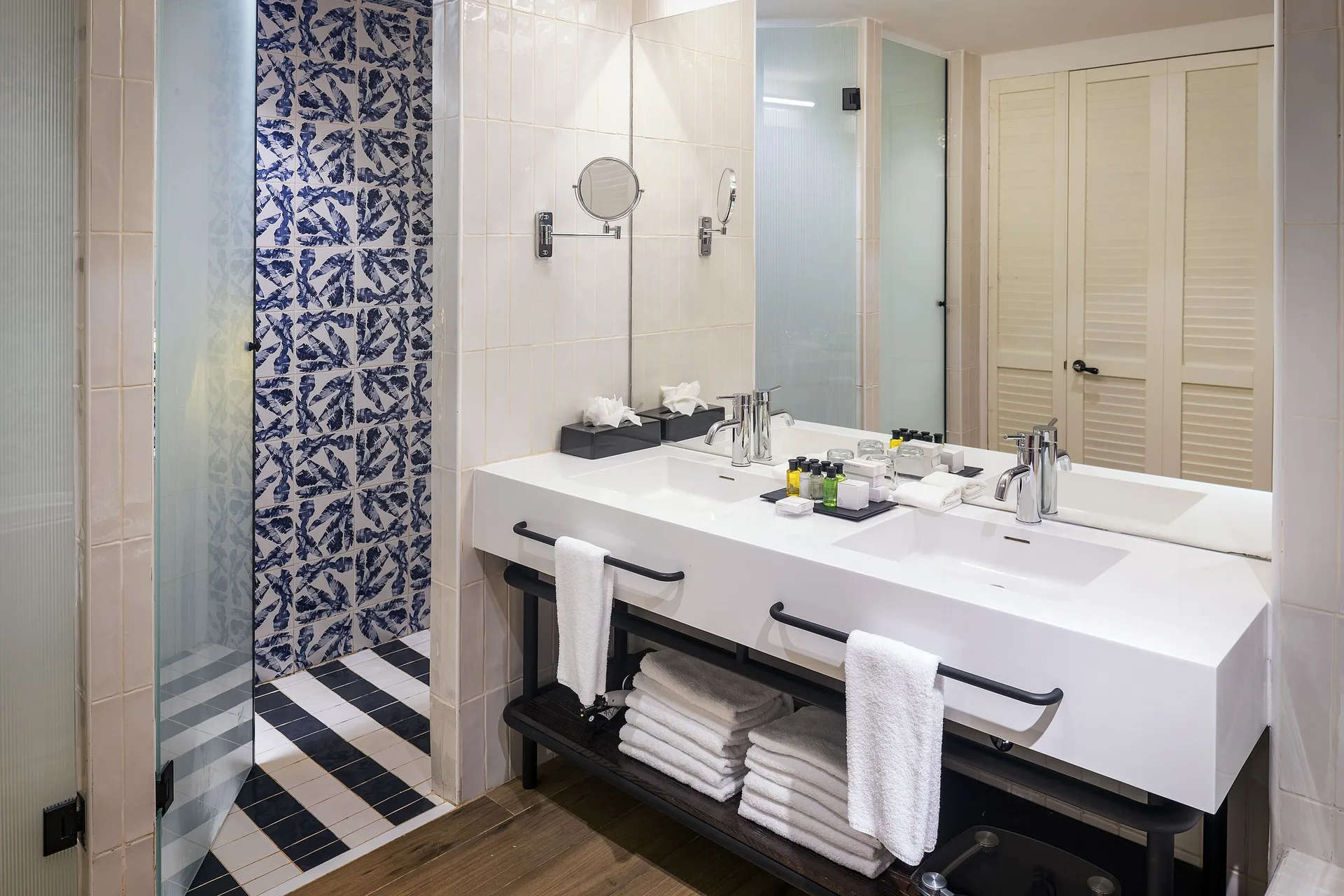 Junior Suite Nature View bathroom at Ocean Coral Spring with double vanity, mirror, and walk-in shower.