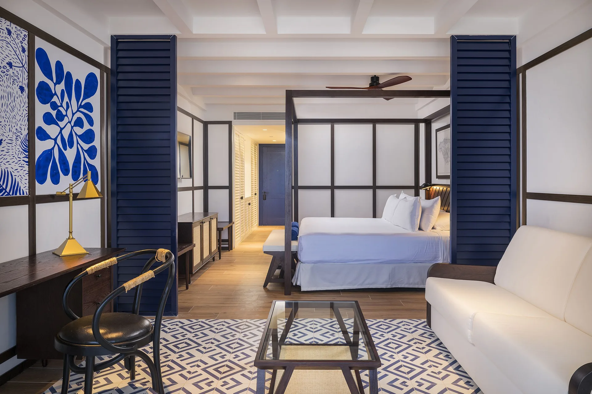 Junior Suite Nature View living and king bed area at Ocean Coral Spring with sofa, desk, and glass table.
