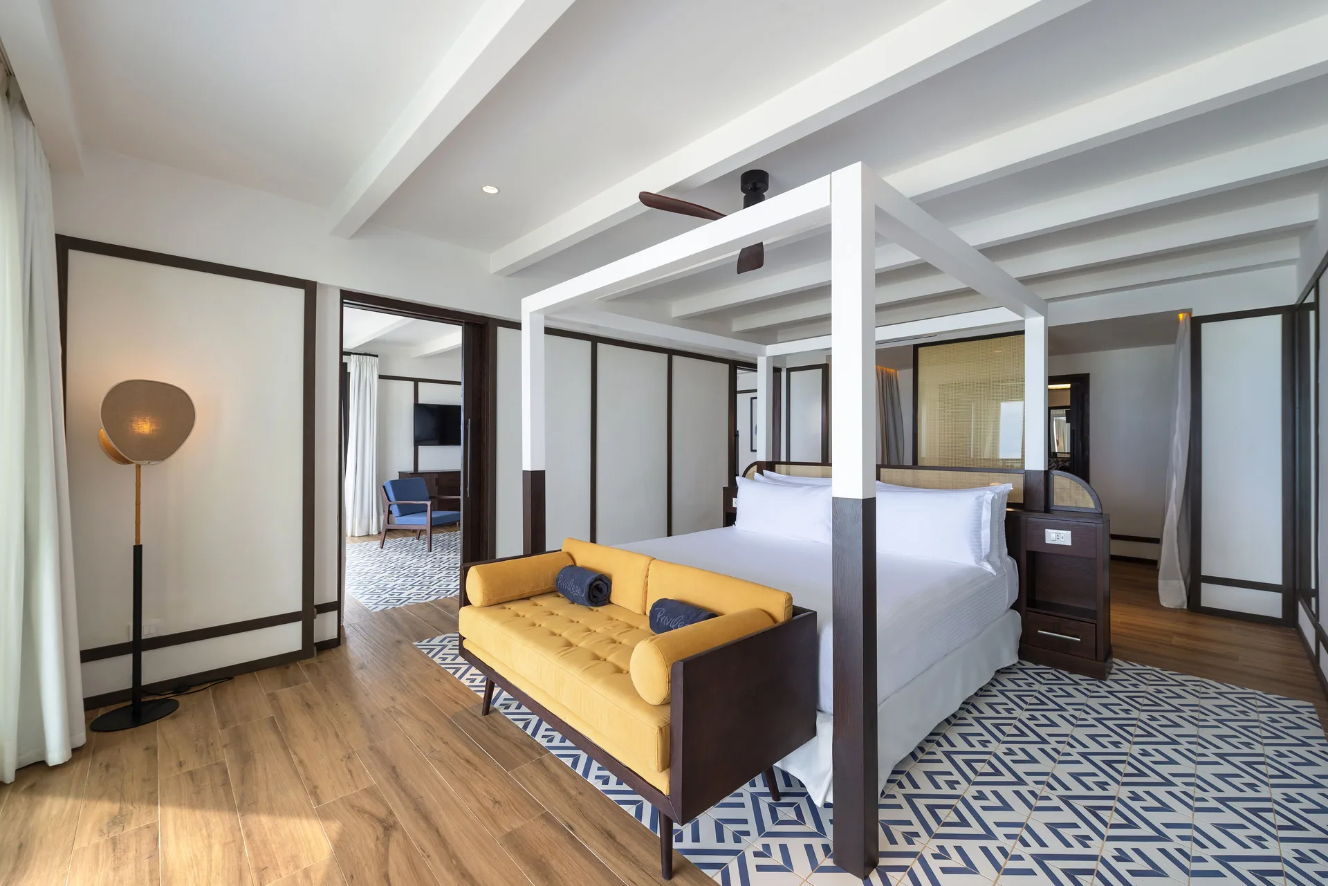 Privilege Master Suite bedroom with canopy bed and yellow sofa at Ocean Coral Spring.