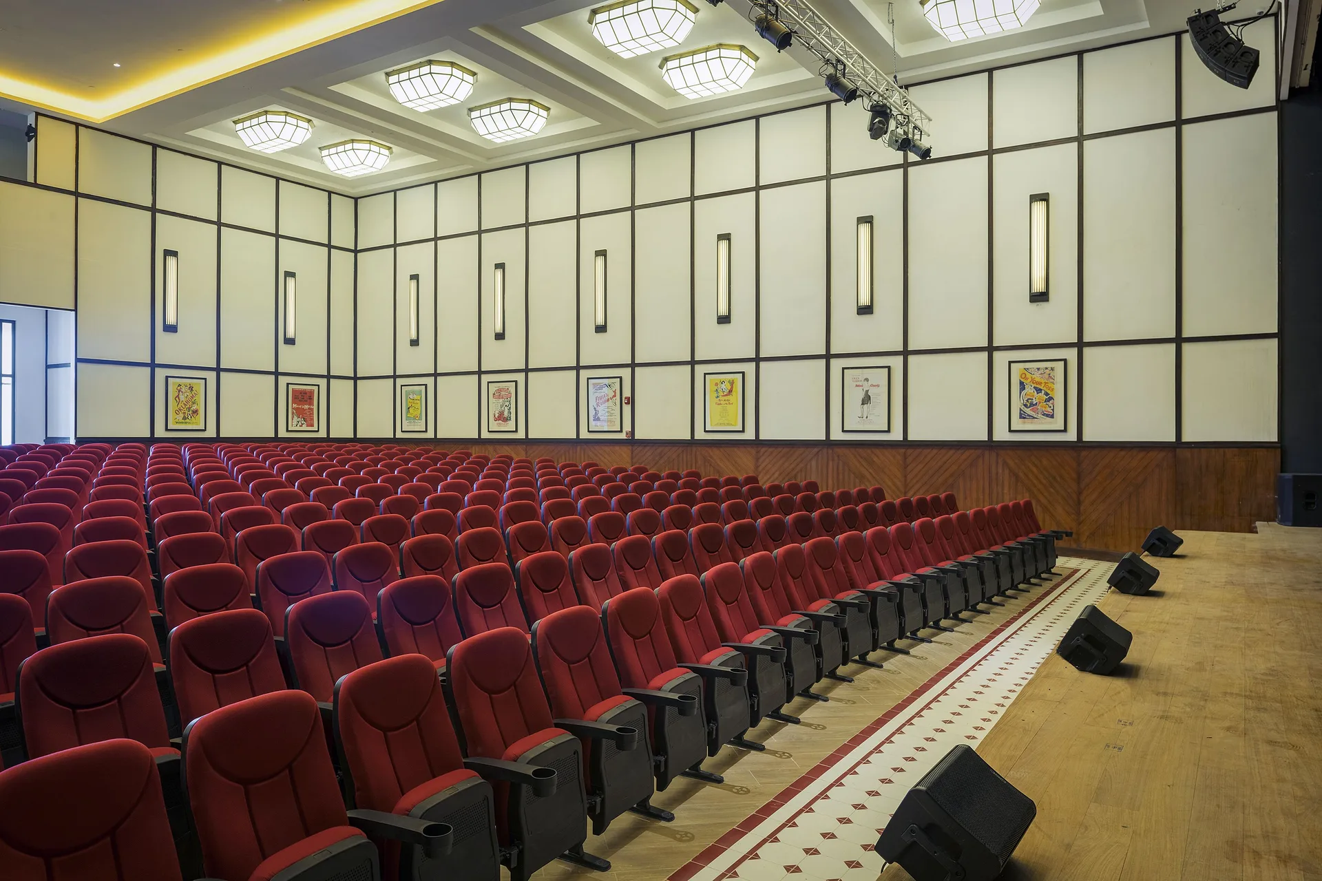 Auditorium with red theater seating and a stage at Ocean Coral Spring.