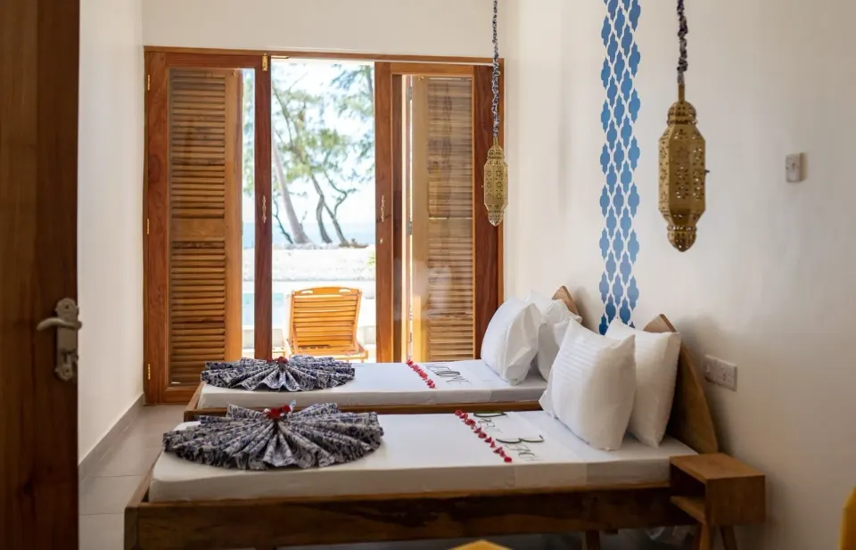 Deluxe Apartment twin beds facing open balcony doors at Orient Beach Hotel.