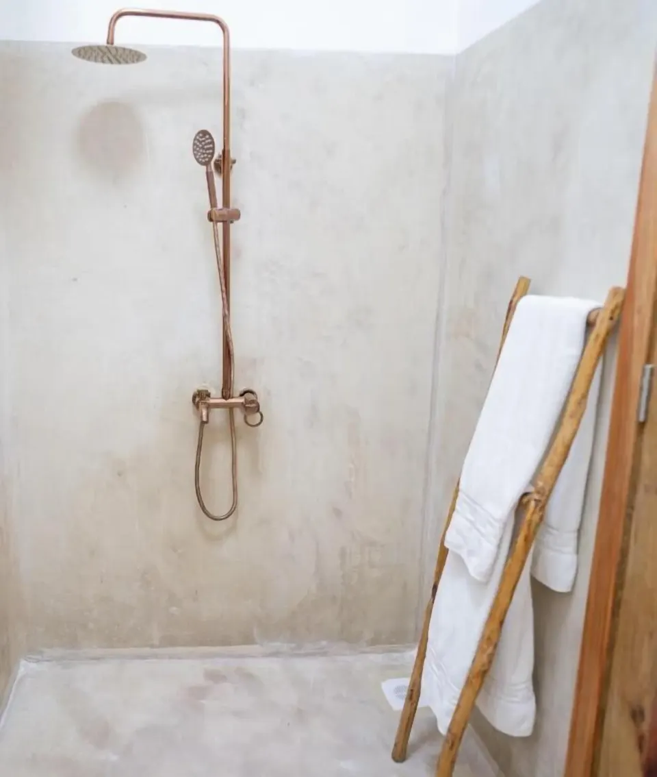Deluxe Apartment walk-in shower with copper-tone fixtures at Orient Beach Hotel.