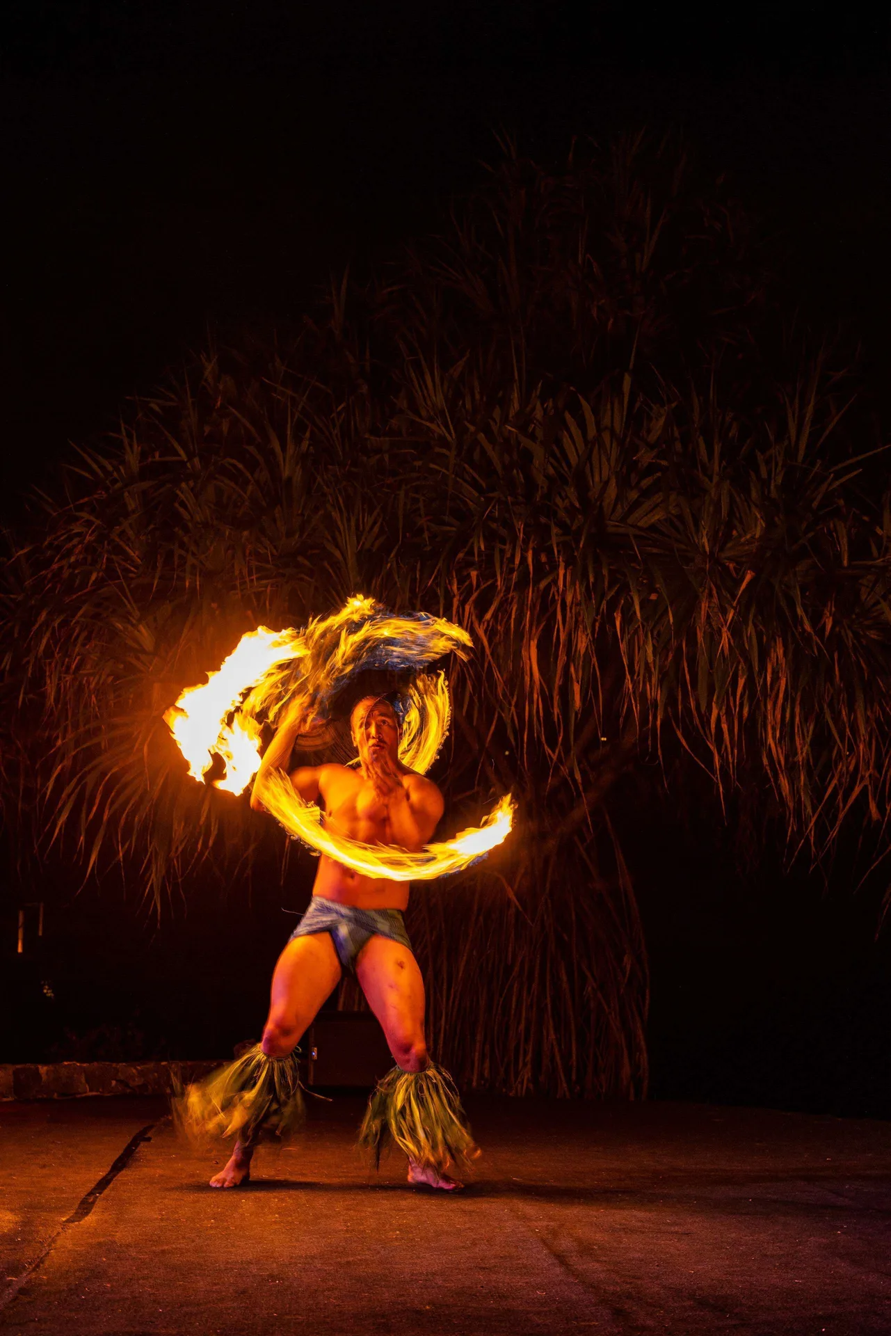 Fire knife performer on an outdoor stage at Outrigger Kona Resort and Spa.