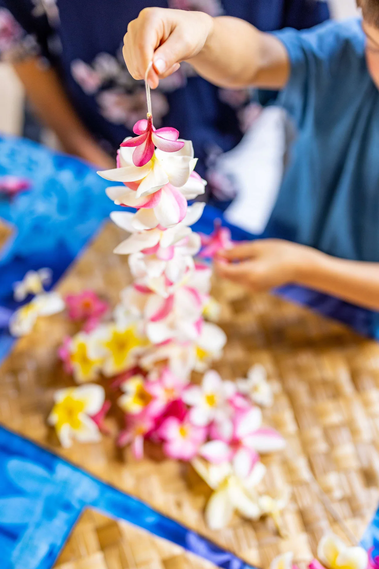 Fresh flower lei being strung by hand at Outrigger Kona Resort and Spa.