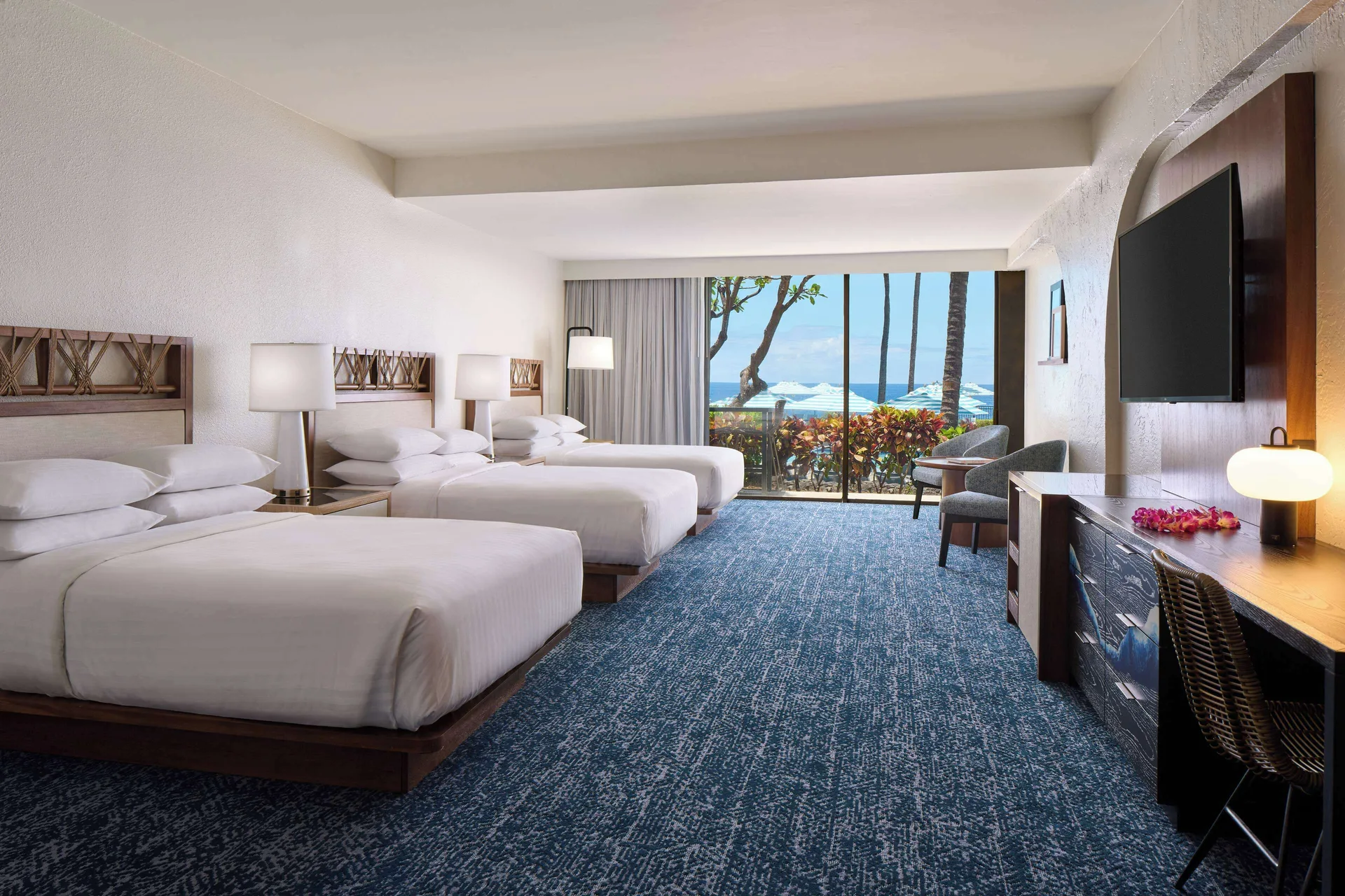 Guest room with two beds, balcony, and pool view at Outrigger Kona Resort and Spa.