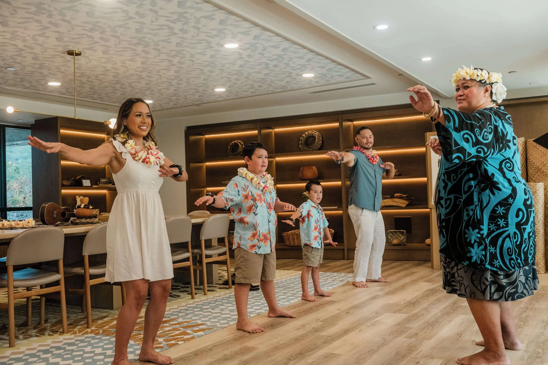 Family learning hula in an indoor resort space at Outrigger Kona Resort and Spa.