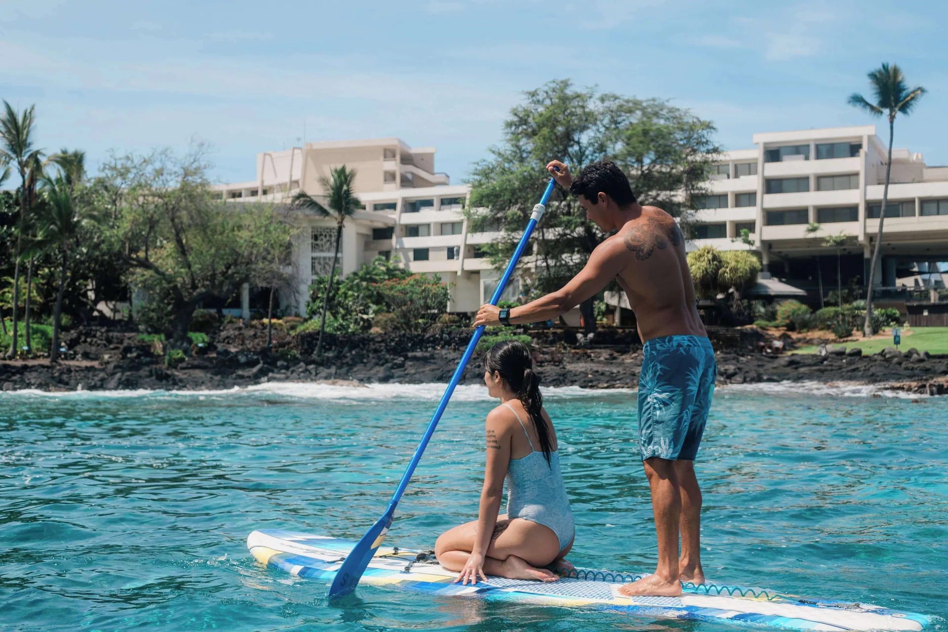 Paddleboarders on the ocean in front of Outrigger Kona Resort and Spa.