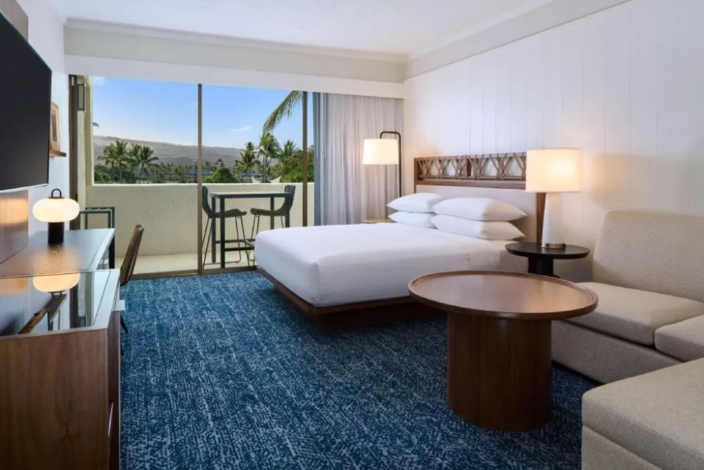 Resort View king room with sofa and balcony at Outrigger Kona Resort and Spa.