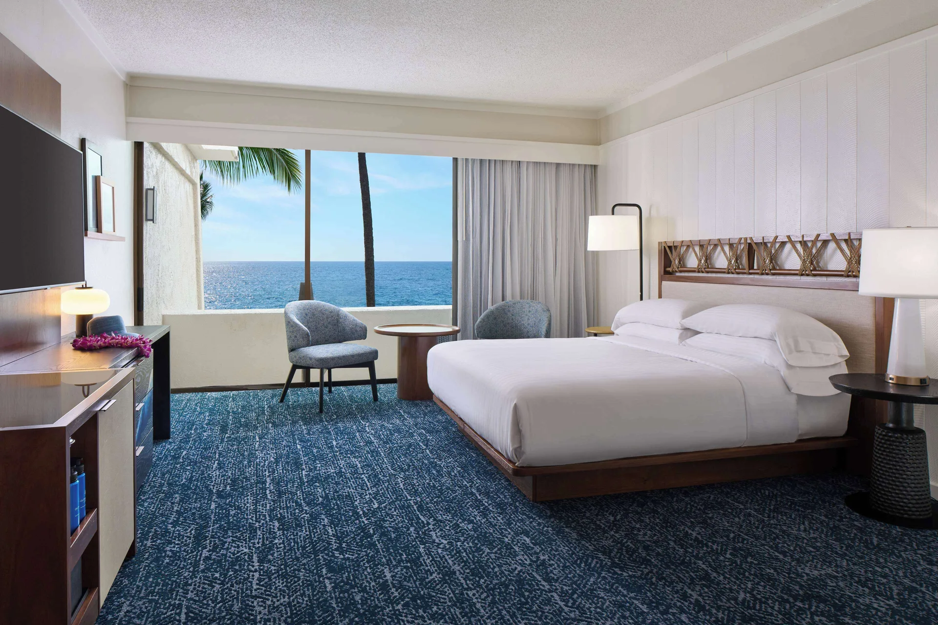 Oceanfront king room with armchairs facing the view at Outrigger Kona Resort and Spa.