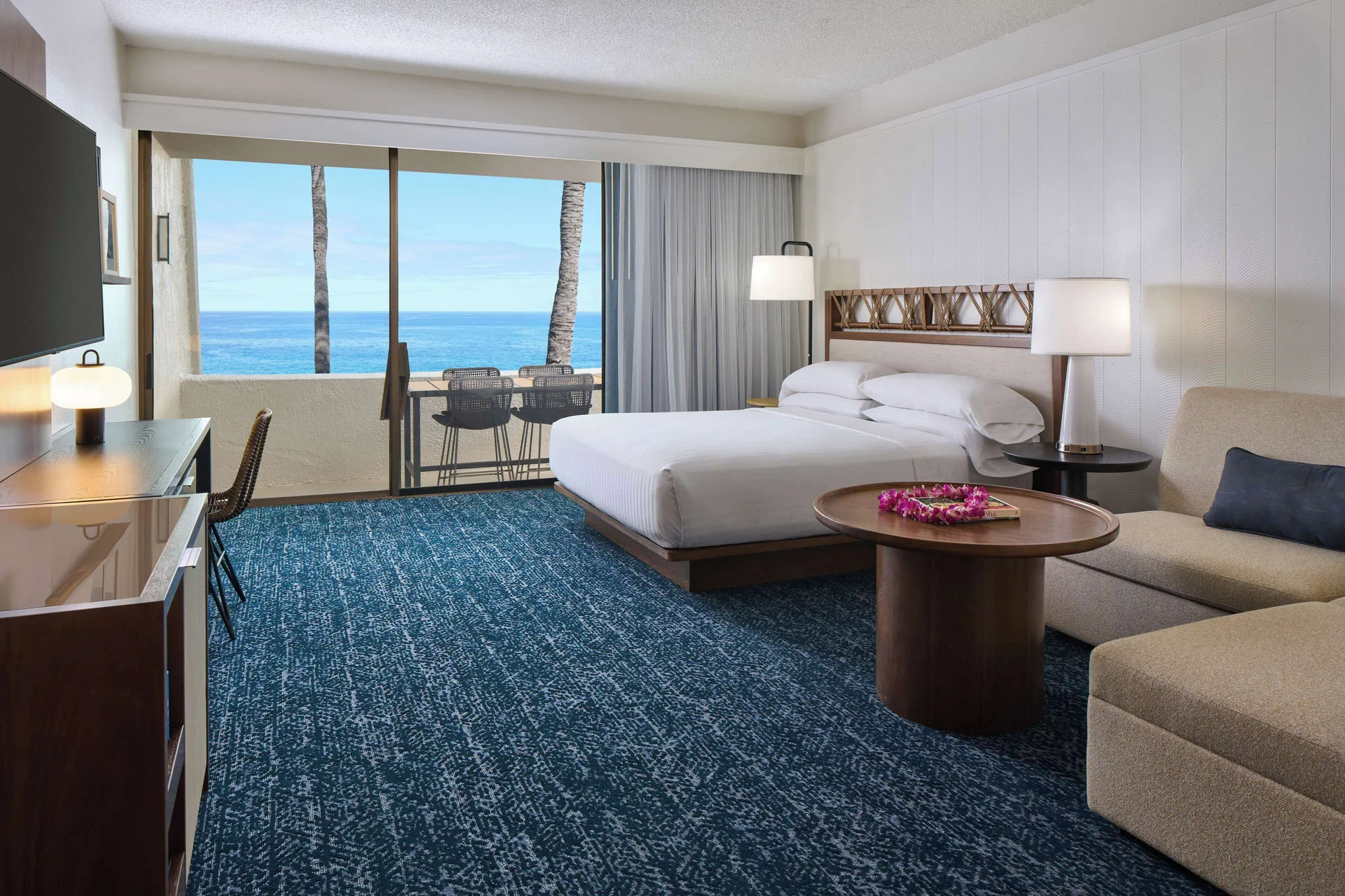 Oceanfront room with king bed and lounge seating at Outrigger Kona Resort and Spa.